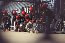 Pit Crew Preparing Tires In Formula One Pit Lane