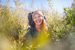 © Trevor Adeline/Caia Image - Portrait laughing young woman with backpack hiking in sunny field