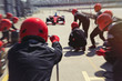 © Sam Edwards/Caia Image - Pit crew ready for nearing formula one race car driver in pit lane