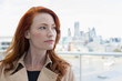 © Martin Barraud/Caia Image - Portrait pensive businesswoman red hair looking away on urban balcony