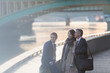 © Martin Barraud/Caia Image - Smiling business people talking at urban waterfront