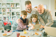 © Tom Merton/Caia Image - Male gay parents children video messaging digital tablet in morning kitchen