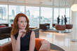 © Martin Barraud/Caia Image - Portrait confident businesswoman red hair in urban highrise office lounge
