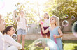© Trevor Adeline/Caia Image - Parents watching daughters blowing bubbles in sunny back yard