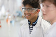 © Martin Barraud/Caia Image - Smiling boy wearing goggles and lab coat in laboratory classroom