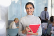 © Sam Edwards/Caia Image - Portrait smiling businesswoman with notebook in conference audience