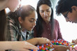 © Martin Barraud/Caia Image - Curious students examining DNA model in classroom