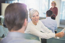 Smiling Businesswoman Talking To Businessman In Conference Audience