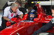 © Sam Edwards/Caia Image - Manager talking to formula one race car driver in repair garage