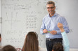© Martin Barraud/Caia Image - Smiling male science teacher leading lesson at whiteboard in classroom