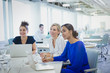 © Sam Edwards/Caia Image - Businesswomen at laptops listening in office meeting