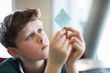 © Martin Barraud/Caia Image - Curious, focused boy examining computer chip in classroom