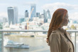 © Martin Barraud/Caia Image - Pensive businesswoman red hair looking at urban city view from balcony, London, UK