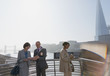 © Tom Merton/Caia Image - Business people using digital tablet at sunny urban waterfront, London, UK