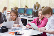 © Robert Daly/Caia Image - Students using digital tablet and laptop in library