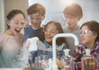 © Martin Barraud/Caia Image - Surprised students conducting scientific experiment, watching chemical reaction in classroom laboratory