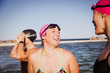 © Caiaimage/Sam Edwards/Caia Image - Laughing female open water swimmers talking at sunny ocean