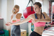 © Sam Edwards/Caia Image - Focused young female boxer stretching, twisting in gym