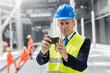 © Rafal Rodzoch/Caia Image - Businessman using digital camera at construction site