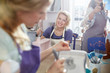 © Agnieszka Olek/Caia Image - Portrait smiling female artist painting in art class workshop