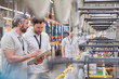 © Agnieszka Olek/Caia Image - Male supervisor worker with clipboard talking in fiber optics factory