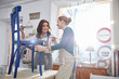 © Agnieszka Olek/Caia Image - Smiling female artists painting chair blue in art class workshop