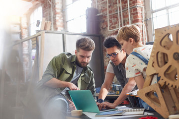 Designers working at laptop in workshop