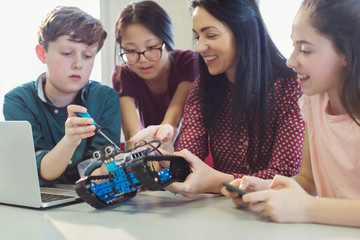 Female teacher students programming assembling robotics in classroom