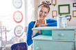 © Agnieszka Olek/Caia Image - Portrait smiling, confident female artist painting side table blue in art class workshop