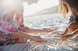© Sam Edwards/Caia Image - Mother and daughter drawing spirals in the sand on sunny summer beach