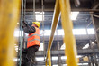 © Agnieszka Olek/Caia Image - Male worker climbing ladder in factory