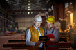 © Agnieszka Olek/Caia Image - Male foreman and engineer using digital tablet in dark factory