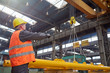 © Rafal Rodzoch/Caia Image - Male worker guiding hydraulic crane in factory