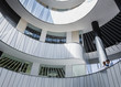 © Caiaimage/Martin Barraud/Caia Image - Businessmen discussing paperwork on architectural, modern office atrium balcony