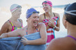 © Caiaimage/Sam Edwards/Caia Image - Laughing female open water swimmers drying off with towels