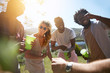 © Trevor Adeline/Caia Image - Laughing young friends drinking and hanging out in sunny summer park