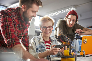 Smiling computer programmers programming robotics