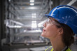 © Martin Barraud/Caia Image - Profile pensive female worker looking up in factory