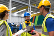© Sam Edwards/Caia Image - Supervisor and workers with clipboard and digital tablet talking in factory
