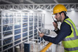 © Martin Barraud/Caia Image - Male supervisor with digital tablet talking, using walkie-talkie n platform in factory