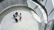 © Caiaimage/Martin Barraud/Caia Image - View from above business people handshaking in round modern office atrium courtyard