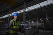 © Martin Barraud/Caia Image - Portrait serious, confident male worker in dark steel factory