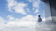 © Caiaimage/Martin Barraud/Caia Image - Pensive businessman standing on modern balcony looking at blue sky clouds