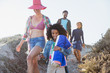 © Sam Edwards/Caia Image - Smiling family walking on sunny summer beach hill