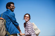 © Sam Edwards/Caia Image - Portrait smiling, affectionate multi-ethnic couple holding hands below sunny summer blue sky