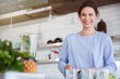 © Sam Edwards/Caia Image - Portrait smiling, confident brunette woman preparing healthy green smoothie in blender in kitchen