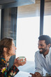 © Sam Edwards/Caia Image - Multi-ethnic couple drinking coffee and talking
