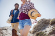 © Sam Edwards/Caia Image - Smiling, enthusiastic couple walking on sunny summer sand beach path