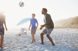 © Sam Edwards/Caia Image - Father and children playing soccer on sunny summer beach