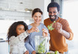 © Sam Edwards/Caia Image - Smiling multi-ethnic family making green smoothie in blender in kitchen